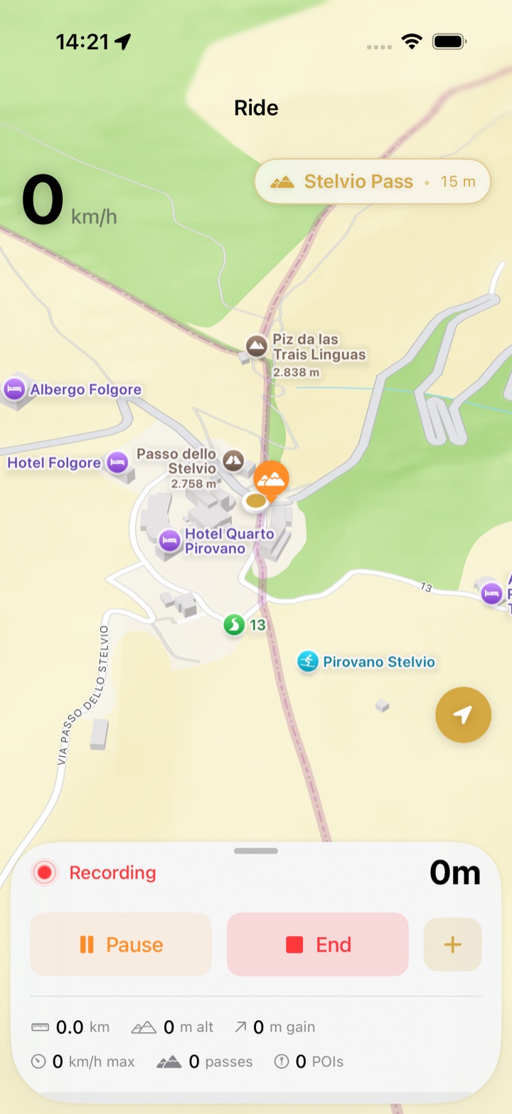 The ride screen at Stelvio with the next-pass pill reading Stelvio Pass 15 m above the map and an orange pass marker next to the rider